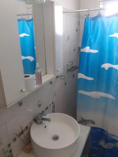a bathroom with a sink and a shower curtain at Latido de Montaña in Bialet Massé