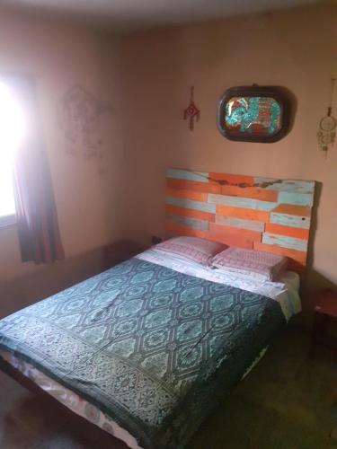 a bedroom with a bed with a wooden headboard and a window at Latido de Montaña in Bialet Massé