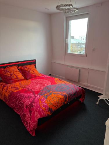 a bedroom with a colorful bed with a window at Petit appartement charmant in Lille