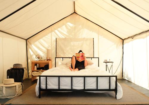 a woman laying on a bed in a tent at AutoCamp Sonoma in Guerneville