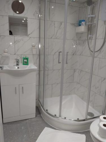 a bathroom with a shower and a sink at Cosy studio flat with free wifi and free parking in Killingbeck