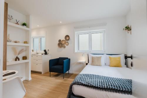 a bedroom with a bed and a blue chair at Póvoa Studios by Pomerania in Póvoa de Varzim