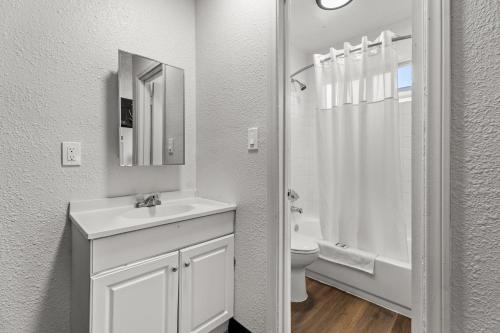a white bathroom with a sink and a toilet at Studio Lodge Hotel in Hewitt