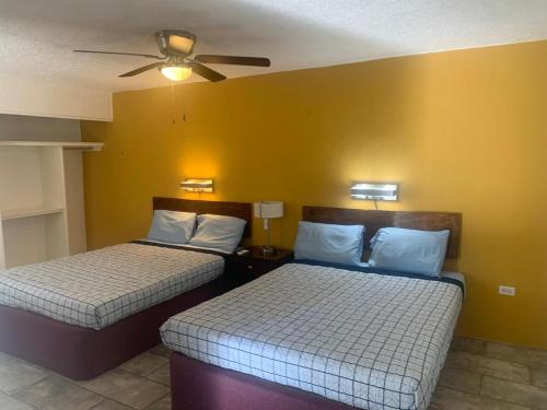 a room with two beds and a ceiling fan at Condomino Maripina in Arena