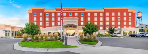 a large red building with a flag in front of it at Hilton Garden Inn Arvada/Denver, CO in Arvada