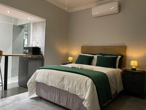 a bedroom with a large bed with green pillows at Luigi's Place in Pretoria