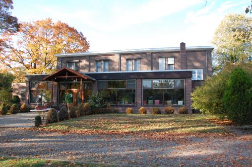 a large brick house with a lot of windows at Stichting InnEssence Stokershorst in Nederweert-Eind