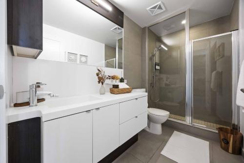 a white bathroom with a shower and a toilet at Condo by CN Tower & Rogers Centre in Toronto