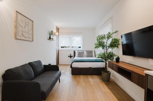 a living room with a couch and a bed at Póvoa Studios by Pomerania in Póvoa de Varzim