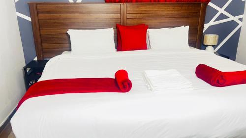 duże białe łóżko z czerwonymi poduszkami w obiekcie Gem Villa Inn w mieście Lesoma