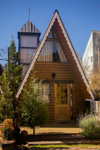 a house with a pointed roof with a yellow door at Altaroma - Pousada e Experiência Gastronômica in Campos do Jordão