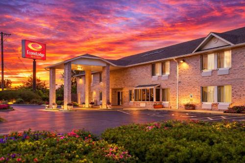 a hotel with a sunset in a parking lot at Econo Lodge Inn & Suites Fairview Heights St Louis in Fairview Heights