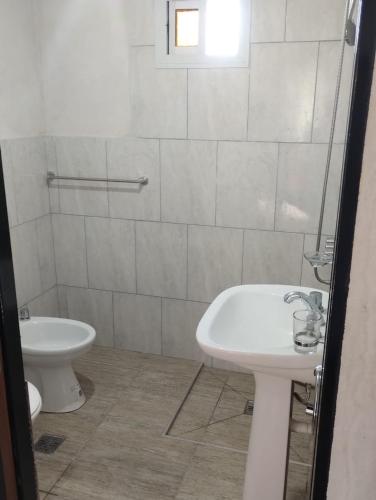 a white bathroom with a sink and a toilet at Cabaña gio in Potrero de Garay