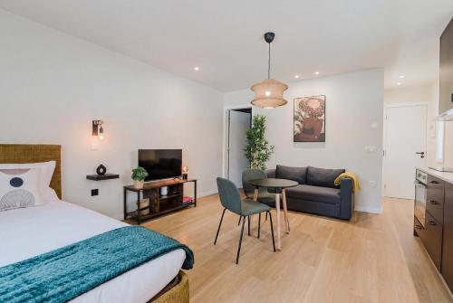 a bedroom with a bed and a couch and a table at Póvoa Studios by Pomerania in Póvoa de Varzim