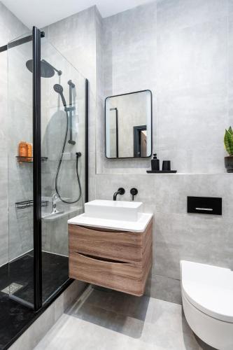 a bathroom with a sink and a shower and a toilet at Luxury High-Ceiling Apartment Central Altrincham in Altrincham
