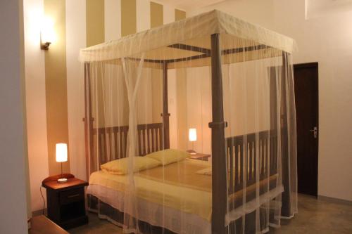 a bedroom with a canopy bed in a room at GalleRetreat in Galle