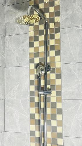 a shower in a bathroom with a tile floor at Gem Villa Inn in Lesoma