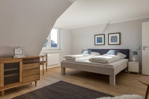a bedroom with two beds and a dresser in it at Sylter Inselglück in Wenningstedt