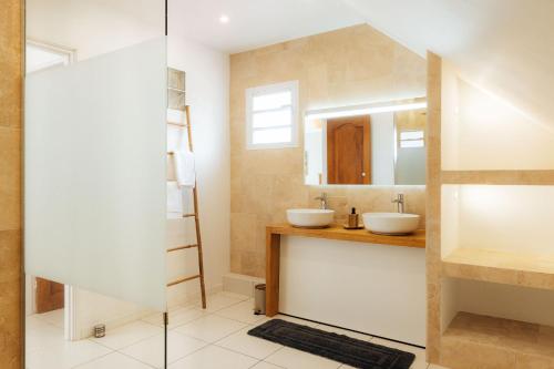 a bathroom with two sinks and a mirror at Villa du Ruisseau in Saint-Louis
