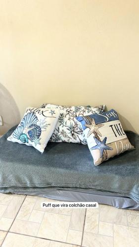 two pillows on top of a bed in a room at Apto na Praia do Cassino in Rio Grande