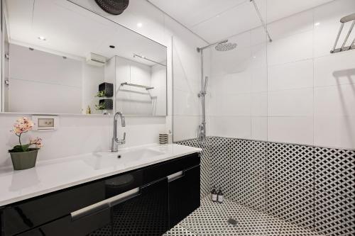 a bathroom with a sink and a shower with a mirror at Luxury Beachside 3BR with Balcony in Tel Aviv