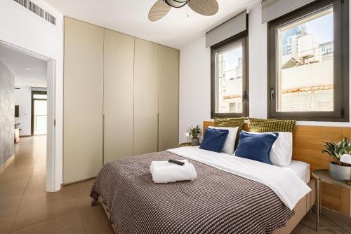 a bedroom with a large bed with blue pillows at Luxury Beachside 3BR with Balcony in Tel Aviv