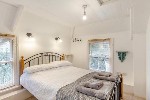 a bedroom with a large bed and two windows at 2 Bed in Little Petherick oc-w28425 in Little Petherick
