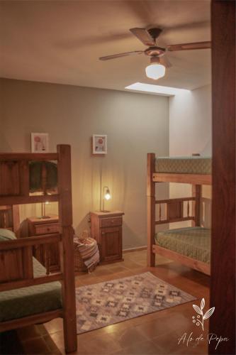 a room with three bunk beds and a ceiling fan at A lo de Pepa in Tupungato