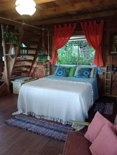 a bedroom with a white bed with a window at Cabaña Agustina in El Soberbio