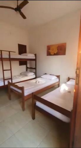 a room with two bunk beds and a ceiling at Pousada Mestre Lua - Itaúnas in Conceição da Barra