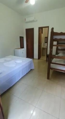 a bedroom with a bed and a wooden chair at Pousada Mestre Lua - Itaúnas in Conceição da Barra