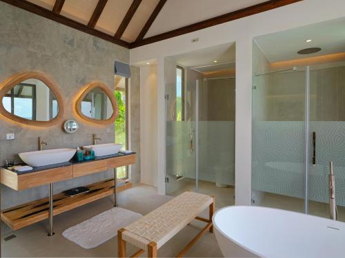 a bathroom with two sinks and a tub and a shower at Meyyafushi Maldives - Premium All Inclusive in Lhaviyani Atoll