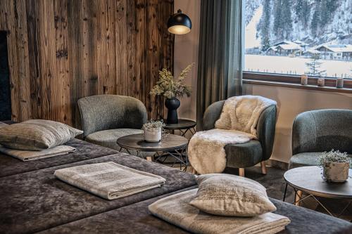 a room with two beds and chairs and a window at Naturhof eibl in Grossarl