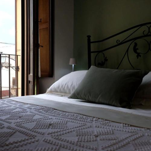 a bedroom with a bed with white sheets and a window at Sotto le 3 Torri in Pacentro