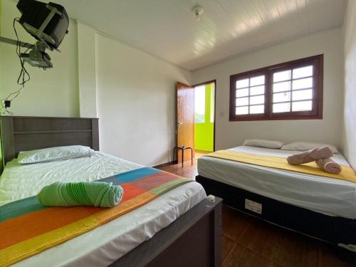 two beds sitting next to each other in a room at Mountain View Guesthouse: Peaceful Retreat near Tiradentes in Prados