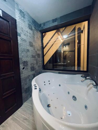 a bath tub in a bathroom with a large mirror at Ćilibar Stara planina in Crni Vrh