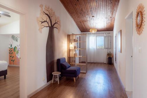 a living room with a tree mural on the wall at Résidence tamarin in Rivière
