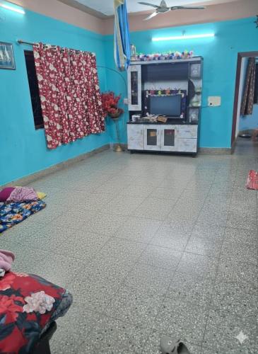 a room with a blue wall and a room with a floor at Joyful Homestay in Mysore