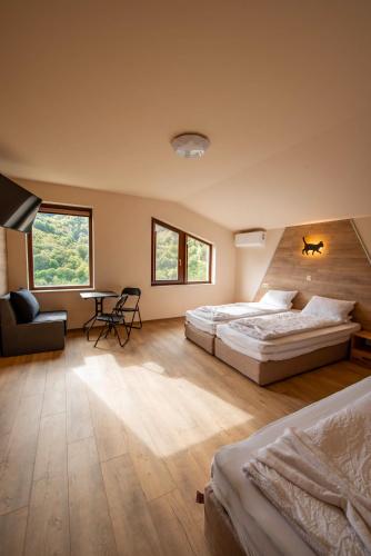 a bedroom with two beds and a table and chairs at Къща за гости Трявна in Tryavna