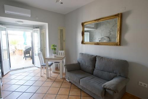a living room with a couch and a table and a mirror at Apartamento turísticos ilusiones 1 in Cazalla de la Sierra