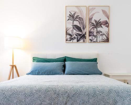 a bedroom with a bed with two paintings on the wall at Castello Living in Turin