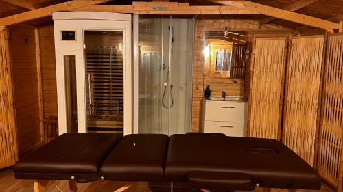 a black leather couch in a room with a shower at Roulotte Natiraa avec sauna et piscine in Tarascon