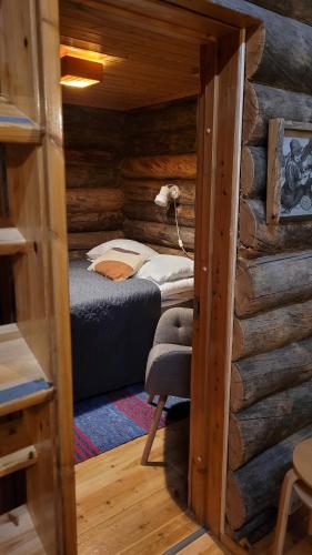 a bedroom with a bed in a log cabin at Holiday Hopukka in Luosto