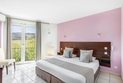 une chambre avec un grand lit et une grande fenêtre dans l'établissement La Frégate, à Collioure