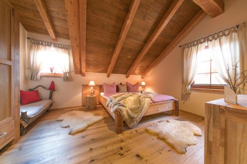 a bedroom with a bed and a couch and windows at Chalets-zum-Ilsetal-Jagd-Chalet-Nr-19 in Ilsenburg