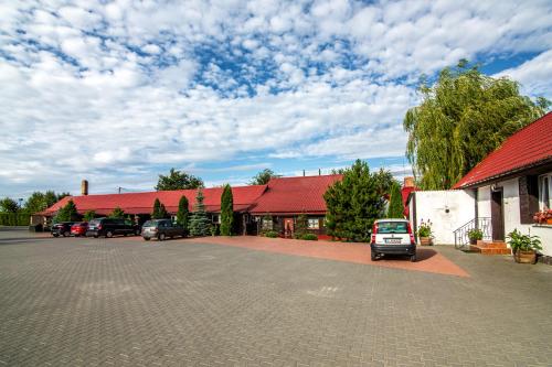 a car parked in a parking lot in front of a building at Karczma Pod Topolami in Ratowo Piotrowo