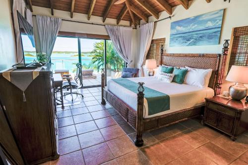 a bedroom with a bed and a view of the ocean at Alta Bella Villa 8 Bdr Oceanfront Nordic Spa in Providenciales