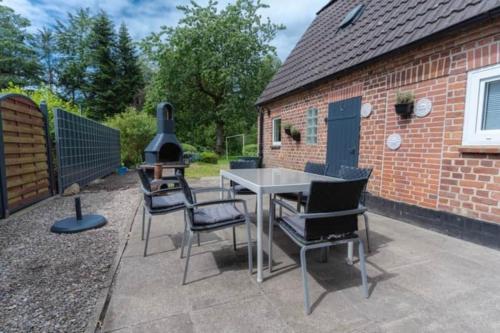 a patio with a table and chairs and a grill at Lykke Suite in Handewitt