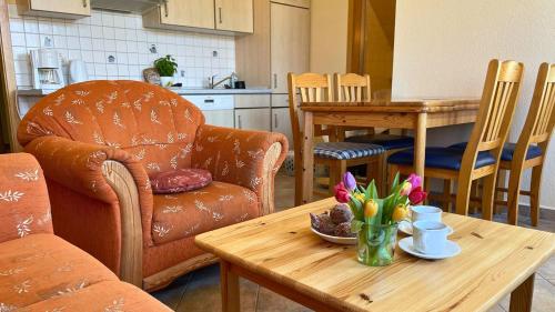 a living room with a table with flowers on it at Bauernhuus 4 in Fehmarn