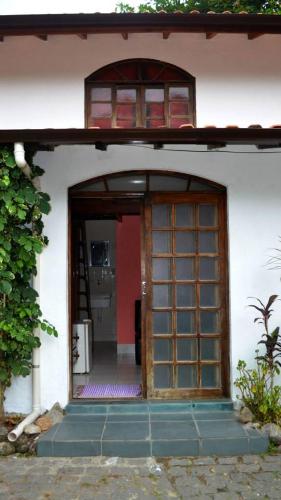 an entrance to a house with a wooden door at Pousada Em Busca do Sol in Trindade